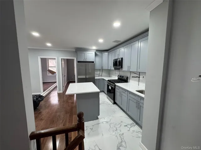a view of kitchen with sink microwave refrigerator and wooden cabinets