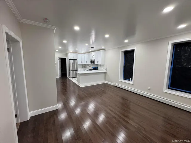a view of a kitchen with wooden floor and electronic appliances