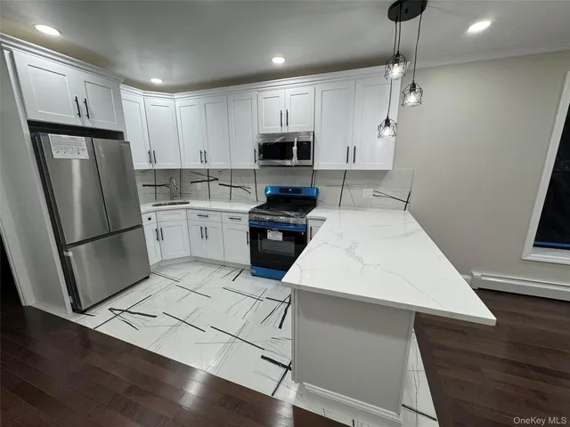 a kitchen with a refrigerator a stove top oven a sink and cabinets