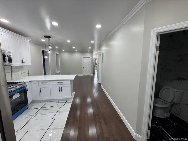 a view of a kitchen with a sink and dishwasher a stove top oven with wooden floor