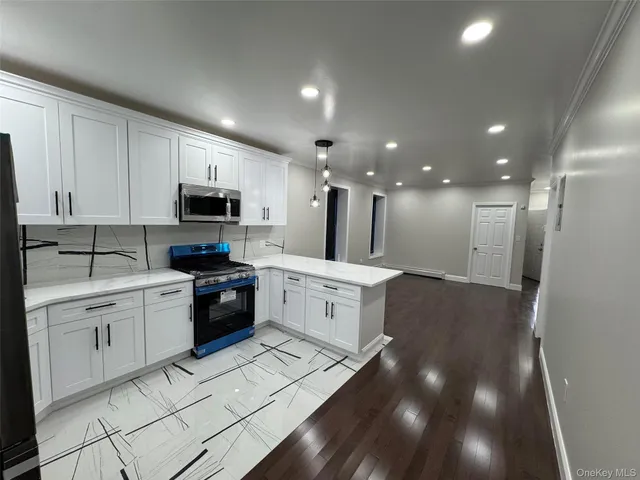 a large kitchen with granite countertop a stove top oven a sink a counter space and cabinets