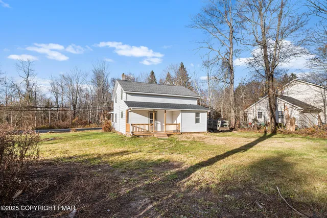 a view of a house with a yard and trees
