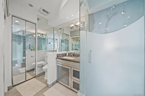 a bathroom with a granite countertop sink mirror and shower