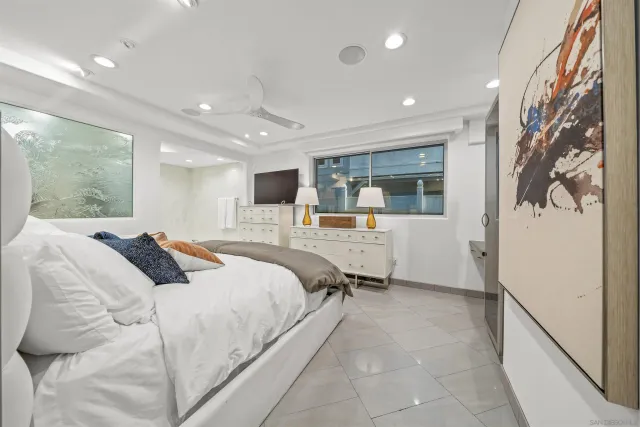 a large bedroom with a bed and wooden floor