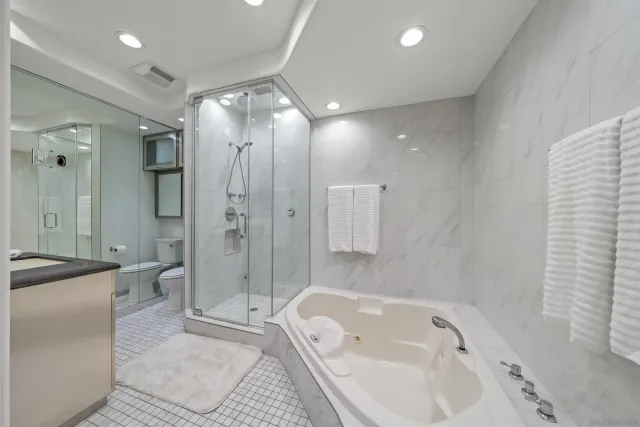 a bathroom with a tub sink shower and mirror
