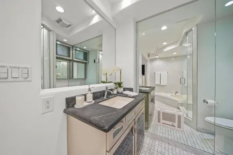 a bathroom with a granite countertop sink a large mirror and a bathtub