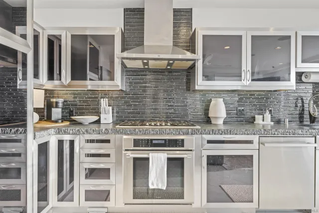 a kitchen with stainless steel appliances granite countertop a stove sink and cabinets