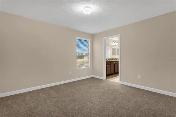 an empty room with windows and cabinet