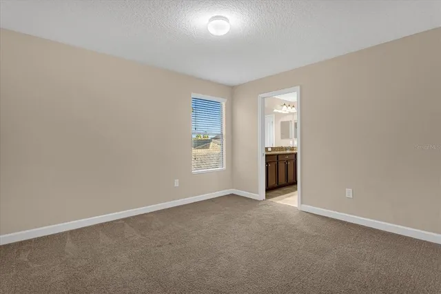 an empty room with windows and cabinet