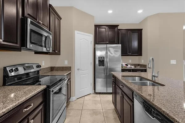 a kitchen with stainless steel appliances granite countertop a sink stove and refrigerator