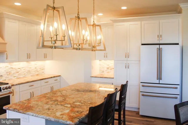 a kitchen with kitchen island sink refrigerator and cabinets