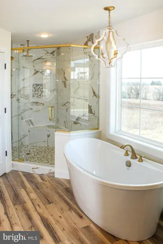 a bath tub sitting next to a window and a shower