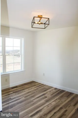 a view of a room with wooden floor and a window