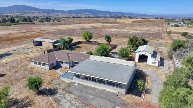 an aerial view of a house with a yard and a large tree