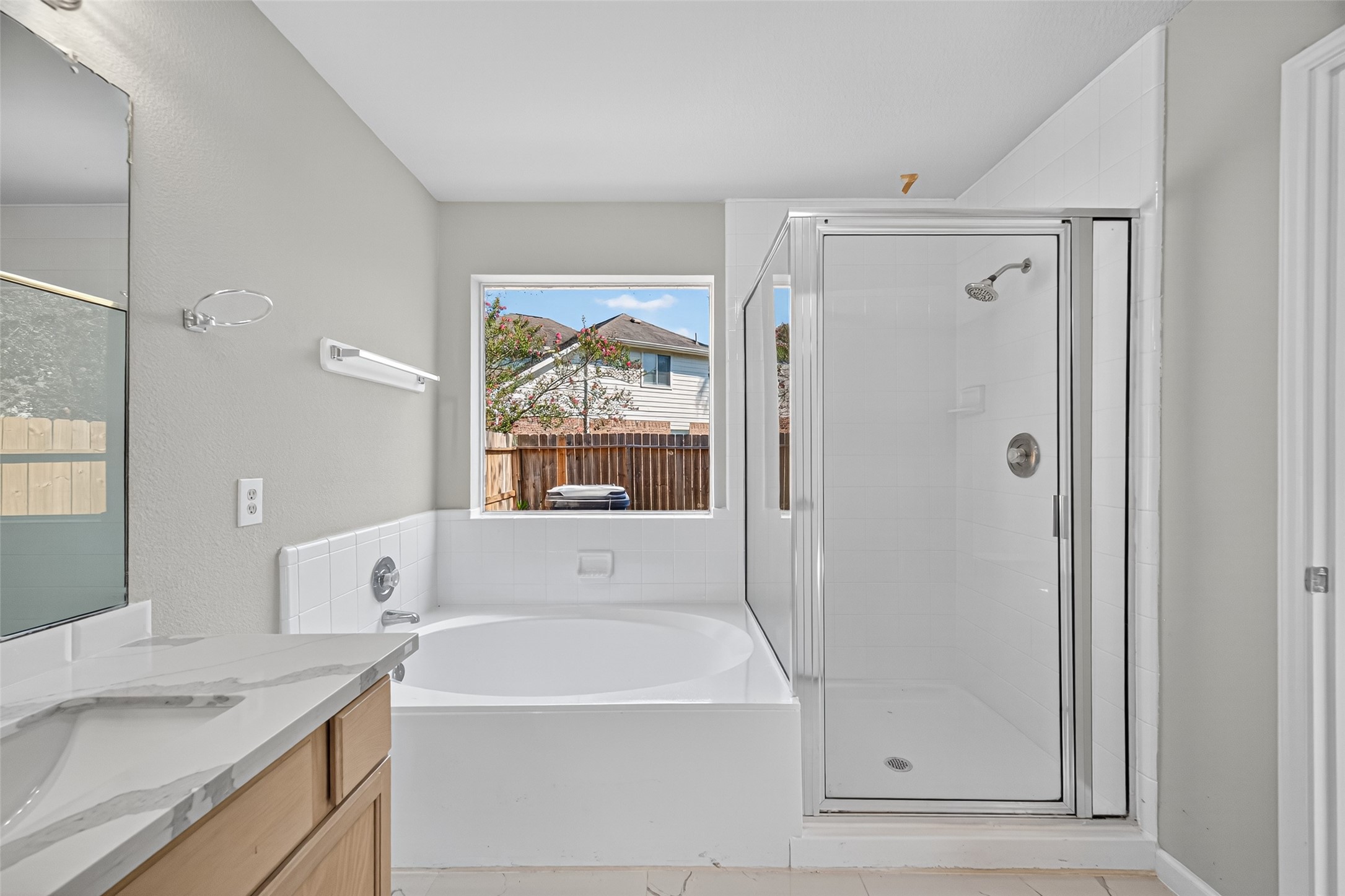 7926 Sundance Court Baytown, TX 77521 - Photo 28 of 32 a bathroom with a granite countertop sink a mirror and a bathtub