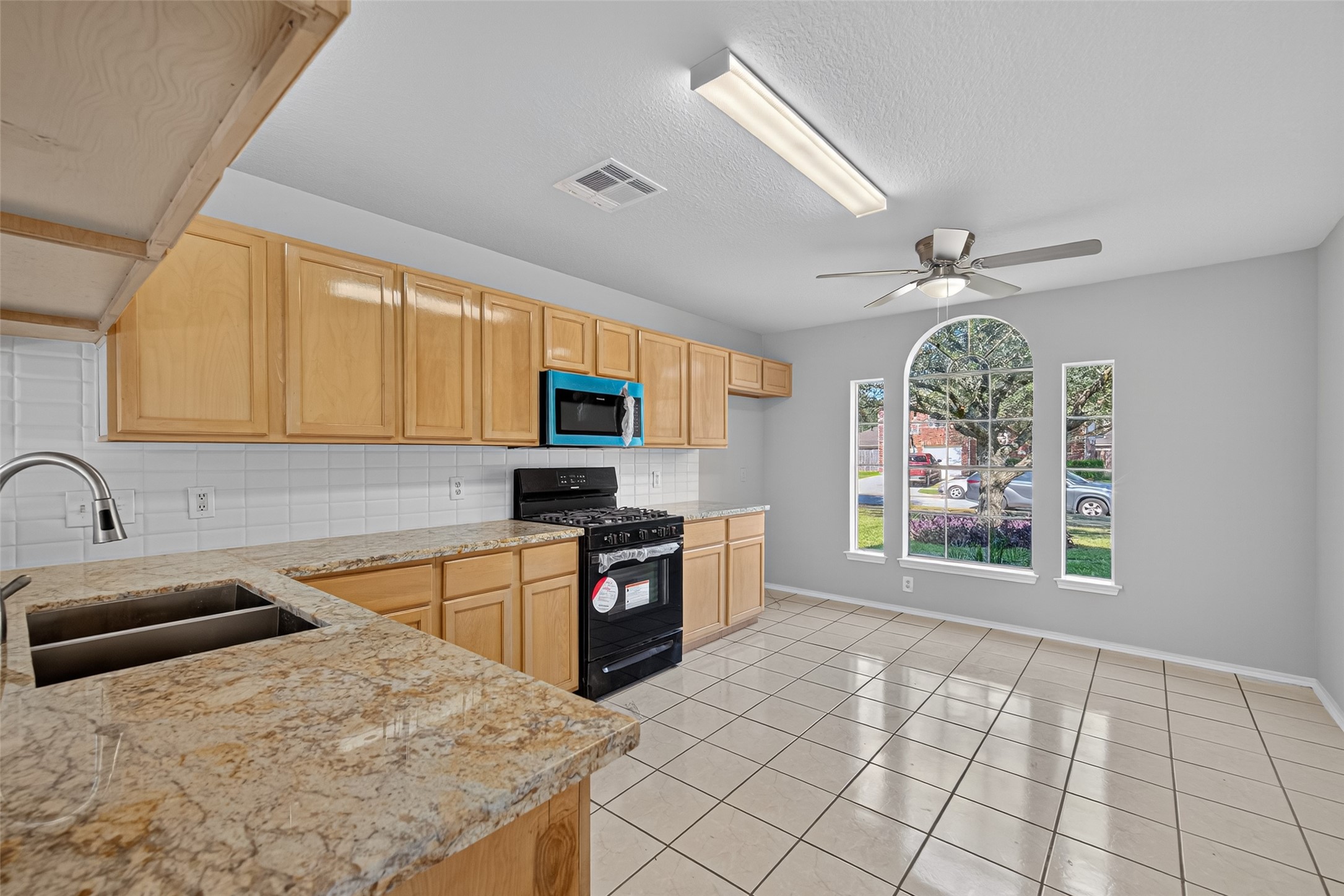 7926 Sundance Court Baytown, TX 77521 - Photo 6 of 32 a kitchen with stainless steel appliances granite countertop a stove top oven a sink a counter space and cabinets