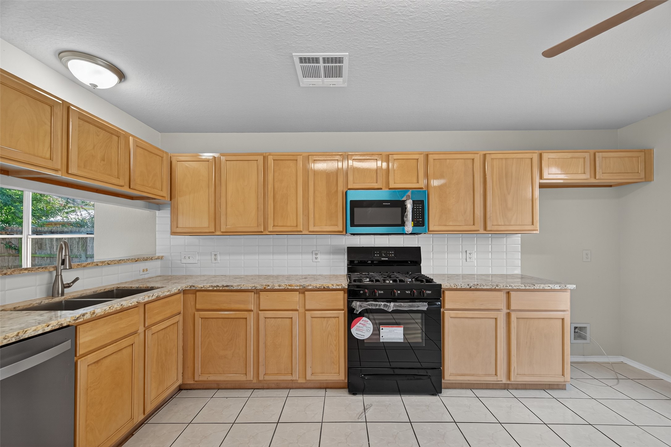 7926 Sundance Court Baytown, TX 77521 - Photo 7 of 32 a kitchen with a stove a sink and a microwave