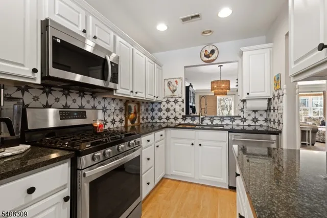 a kitchen with stainless steel appliances granite countertop a stove and a microwave