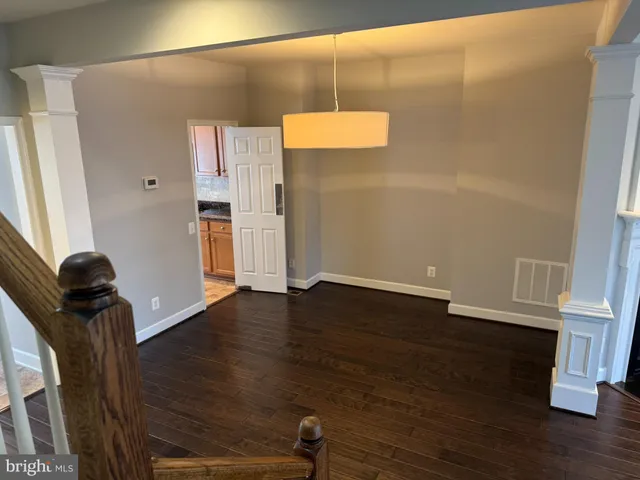an empty room with wooden floor and fireplace
