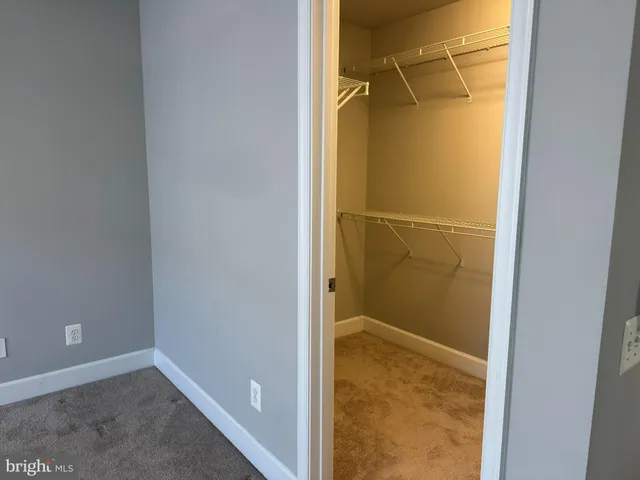 a view of a hallway with wooden floor and a living room