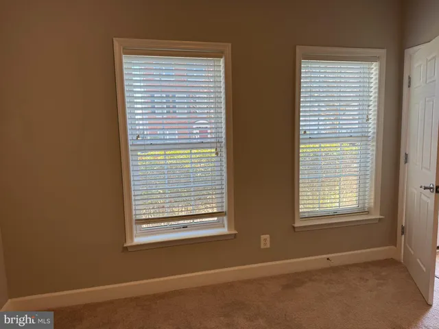 an empty room with wooden floor fireplace and cabinet