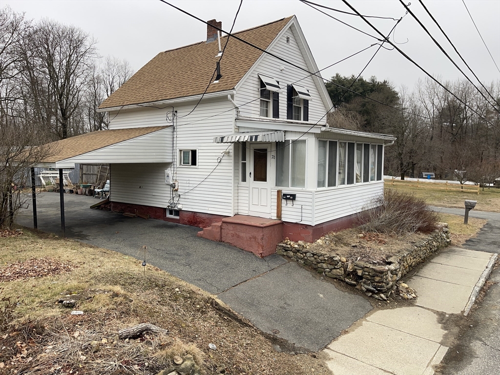 76 Aspen Street Ware, MA 01082 - Photo 5 of 25 a view of a white house with a yard and lawn chairs under an umbrella