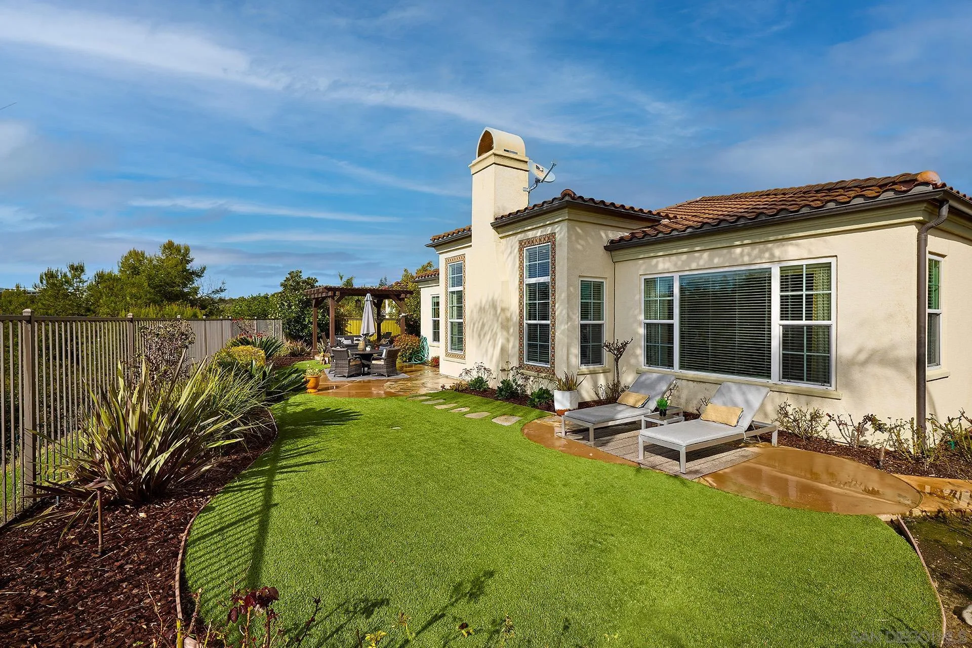 6615 Halite Place Carlsbad, CA 92009 - Photo 33 of 56 a view of a backyard with table and chairs potted plants and large tree