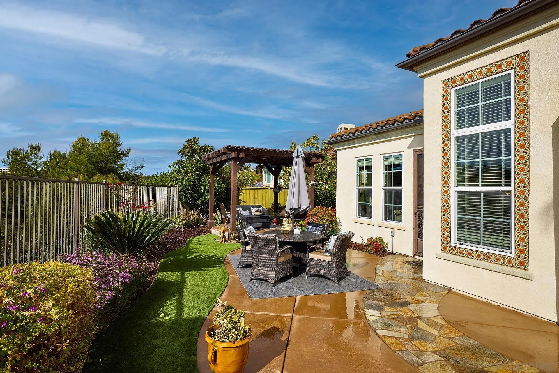 6615 Halite Place Carlsbad, CA 92009 - Photo 34 of 56 a view of a patio with couches chairs potted plants and floor to ceiling window