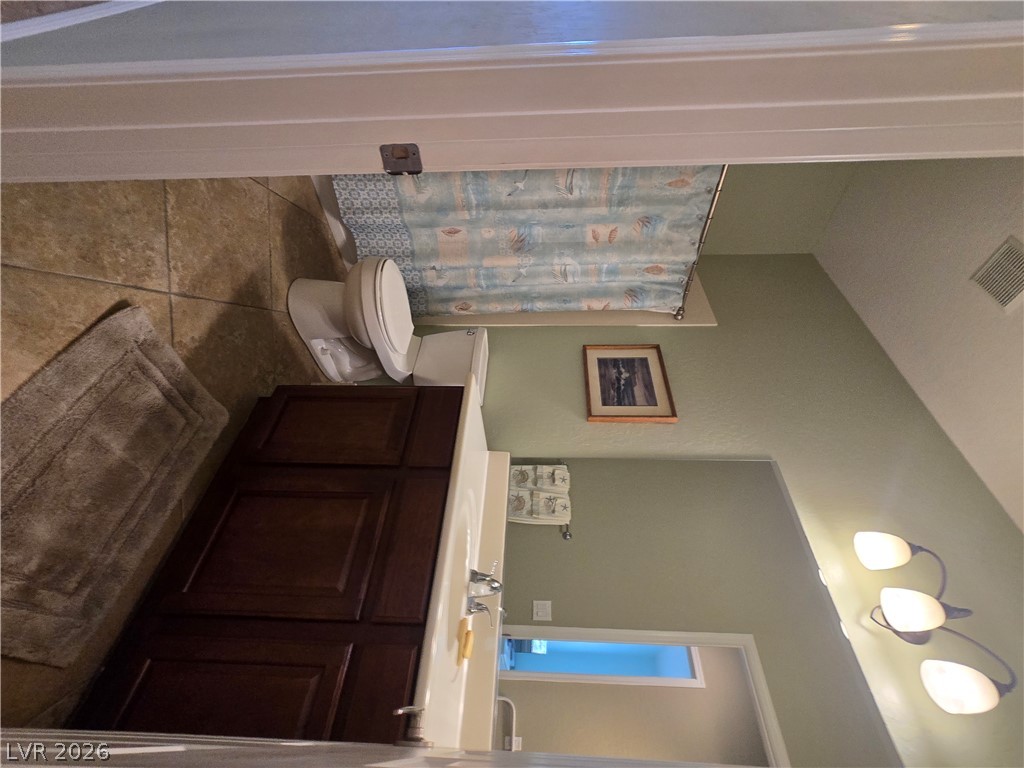 2567 Dirleton Place Henderson, NV 89044 - Photo 44 of 67 Guest Bathroom. The bathroom features a sleek vanity and commode, with practical tile flooring.