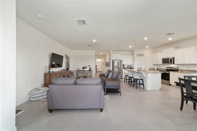 a living room with furniture kitchen view and a dining table