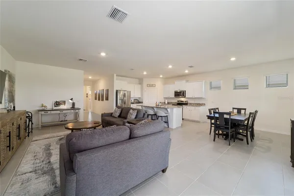 a living room with furniture and a refrigerator