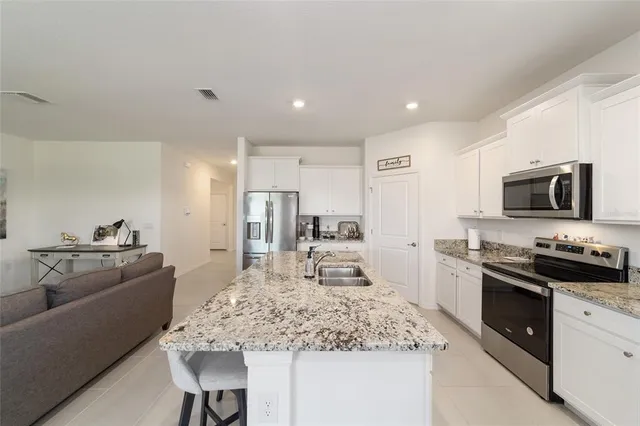 a large kitchen with kitchen island a sink stove and view living room