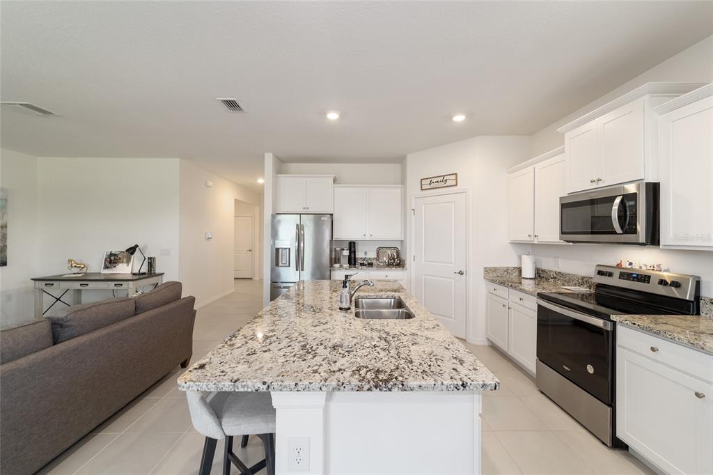 5252 Northwest 46th Lane Road Ocala, FL 34482 - Photo 18 of 51 a kitchen with stainless steel appliances granite countertop a sink stove and refrigerator