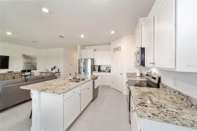 a living room with granite countertop couches and a flat screen tv