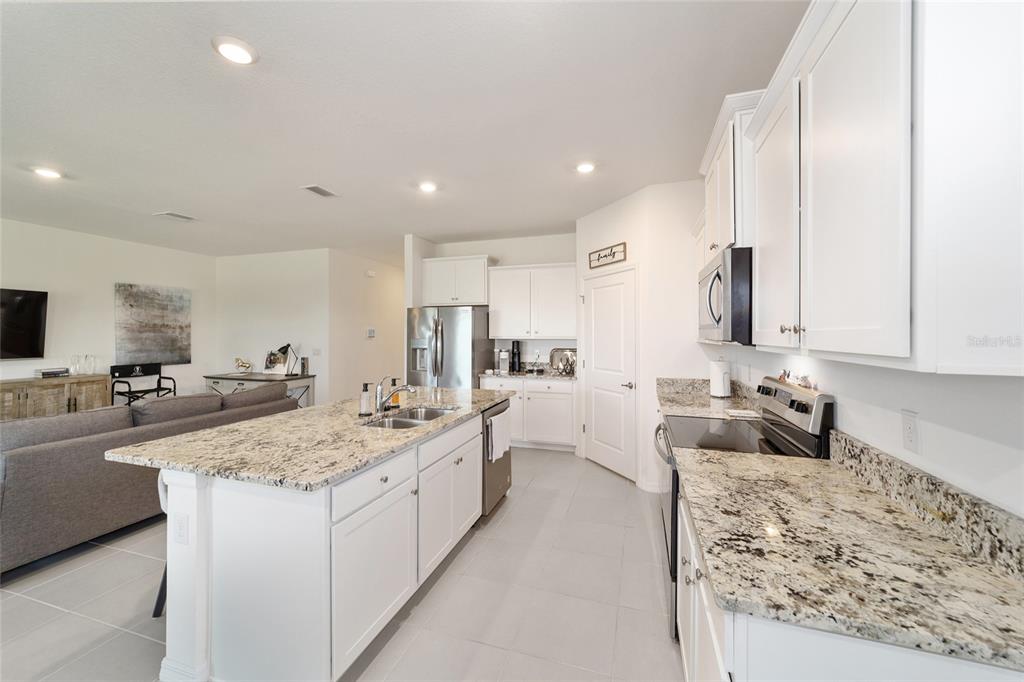 5252 Northwest 46th Lane Road Ocala, FL 34482 - Photo 19 of 51 a large kitchen with kitchen island a sink stove and view living room