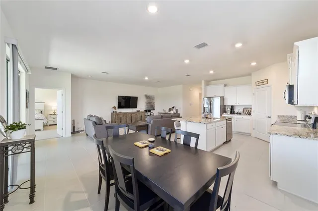 a living room with furniture and a dining table with kitchen view