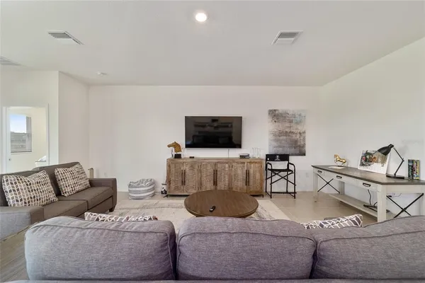 a living room with furniture and a view of kitchen