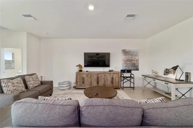 a living room with furniture and a view of kitchen