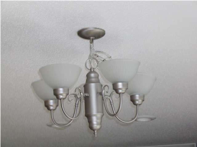 311 Dahlquist Drive Crestview, FL 32539 - Photo 4 of 14 a table with a vase of flowers and a chandelier fan