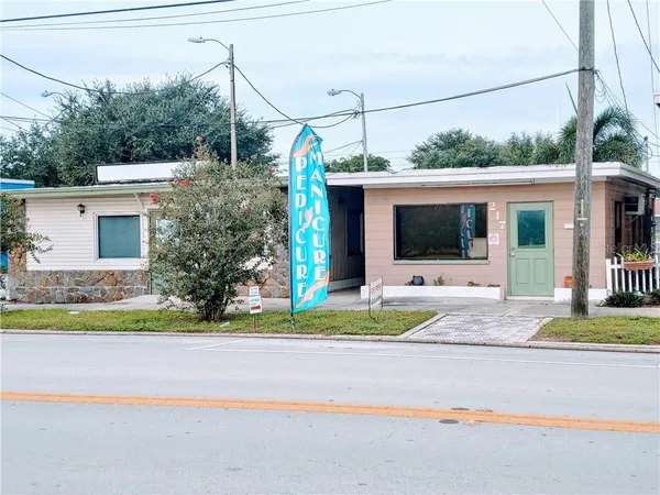 a front view of a house with a yard and potted plants