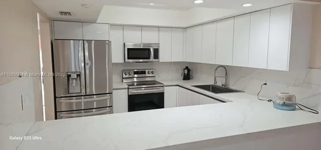 a kitchen with stainless steel appliances a refrigerator sink and microwave