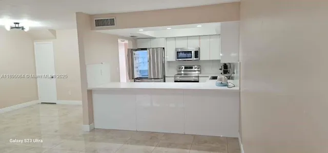 a kitchen with stainless steel appliances a refrigerator and cabinets