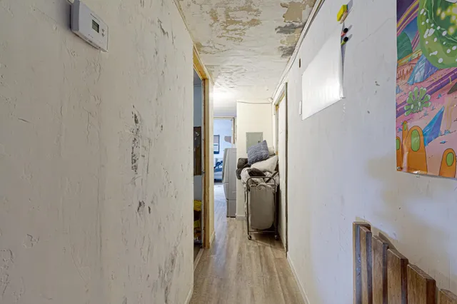 a view of a hallway with a livingroom and a bathroom