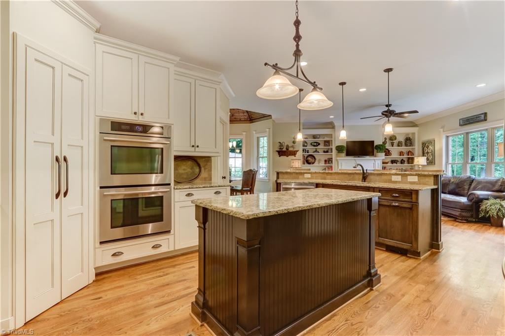 5807 Bison Drive Oak Ridge, NC 27310 - Photo 14 of 39 Another view of the kitchen. double ovens, soft close cabinetry, wood shelving in pantry, 5 burner cooktop.