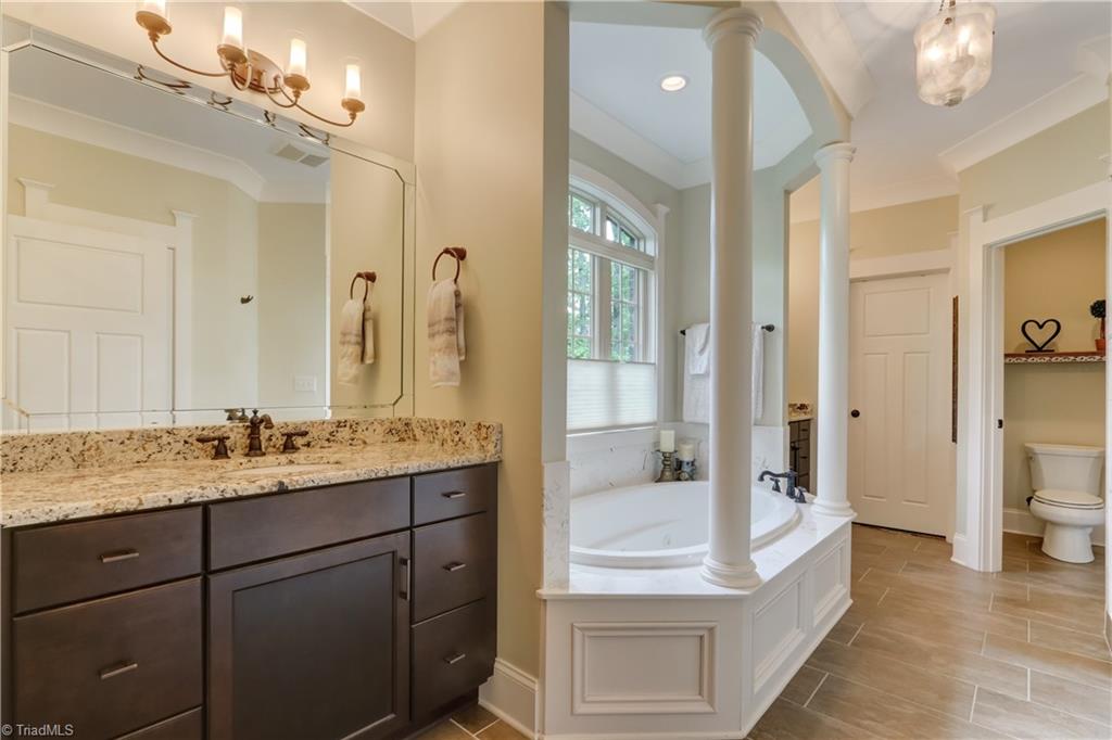 5807 Bison Drive Oak Ridge, NC 27310 - Photo 18 of 39 Double vanities with granite countertop, tile flooring and large jetted tub.