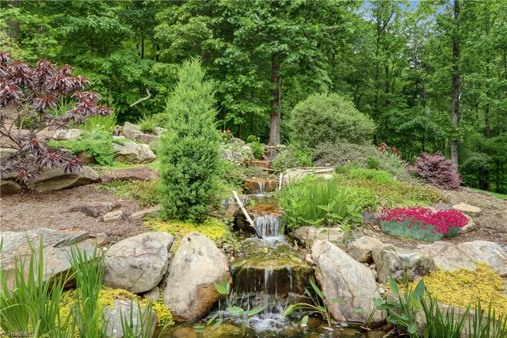 5807 Bison Drive Oak Ridge, NC 27310 - Photo 7 of 39 Waterfalls going into Koi Pond. Stone patio surrounds the pond.
