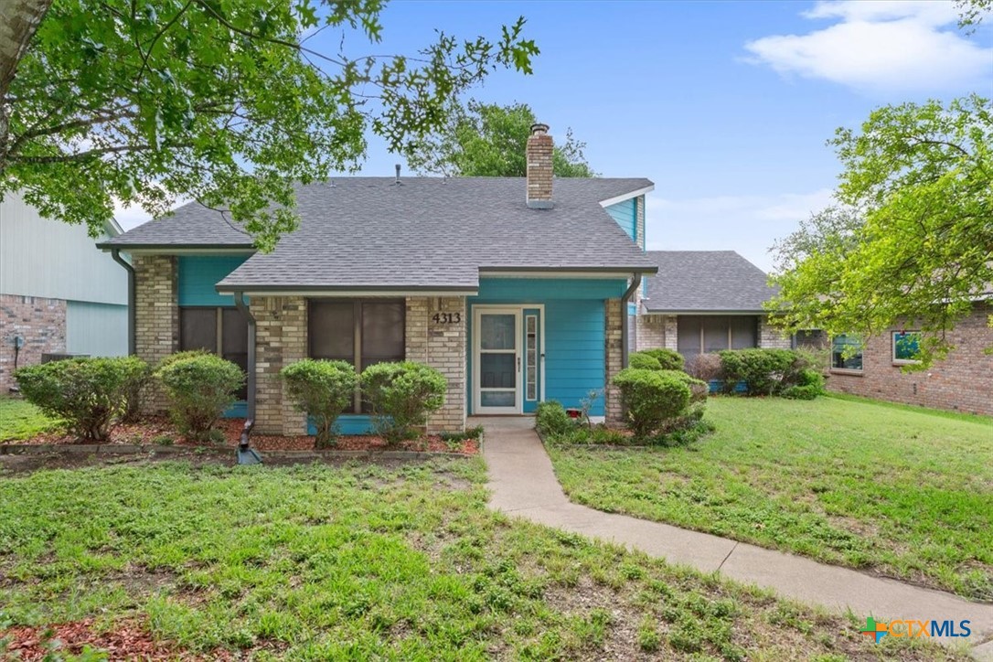 a front view of a house with a yard and potted plants