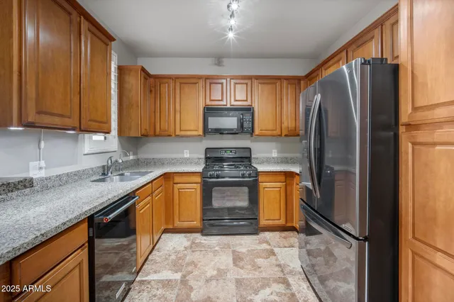 a kitchen with granite countertop wood cabinets and a stove top oven