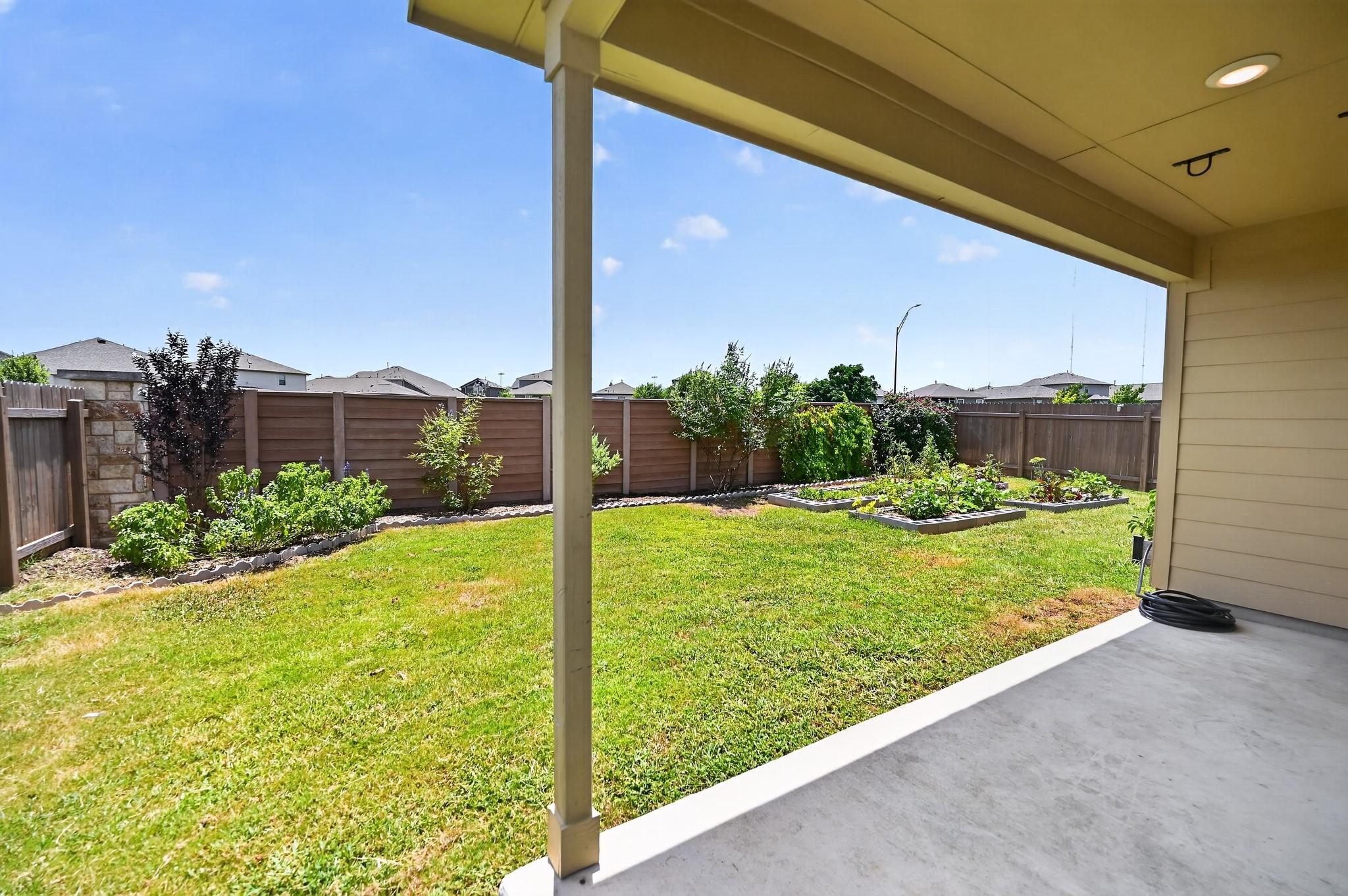 128 Konik Road Georgetown, TX 78626 - Photo 23 of 34 A verdant backyard retreat featuring raised garden beds and ample green space, perfect for outdoor living.