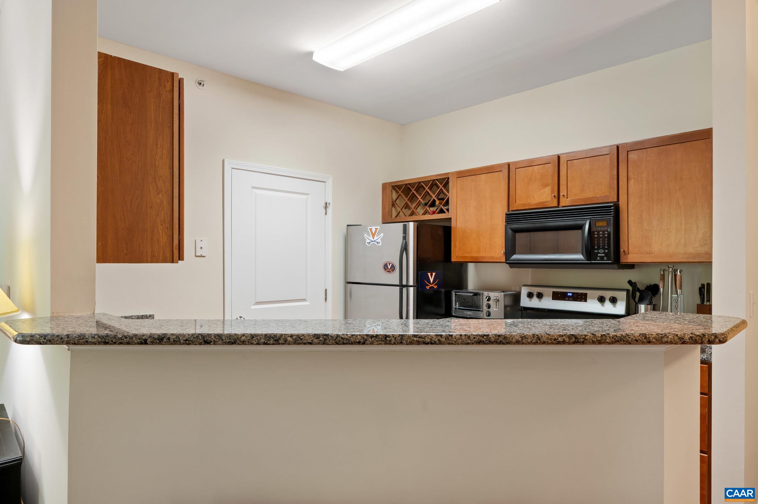 765 Walker Square, Unit 2D Charlottesville, VA 22903 - Photo 7 of 33 a kitchen with stainless steel appliances granite countertop a sink and a microwave